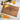 A personalized cutting board made of luxurious walnut wood engraved with a large monogram “W” topped with a crown, the family name “Winston” across the center, and “Sarah & Adam” with “Est. 10.15.22” encircling the design. The board is styled on a clean white background beside red and green grapes, a wine bottle, a glass of golden wine, cheddar cheese cubes, crackers, and fresh heirloom carrots. This elegant custom cutting board makes the perfect cutting board gift for weddings, anniversaries, or homeowners