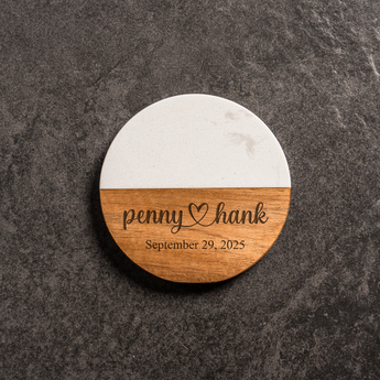 Round wooden coaster with marble bottom on a dark surface