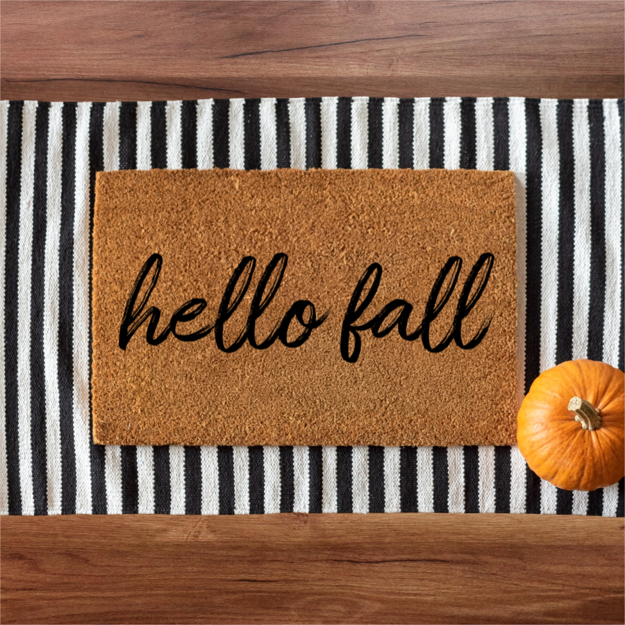 Doormat with 'hello fall' text on a striped rug with a pumpkin