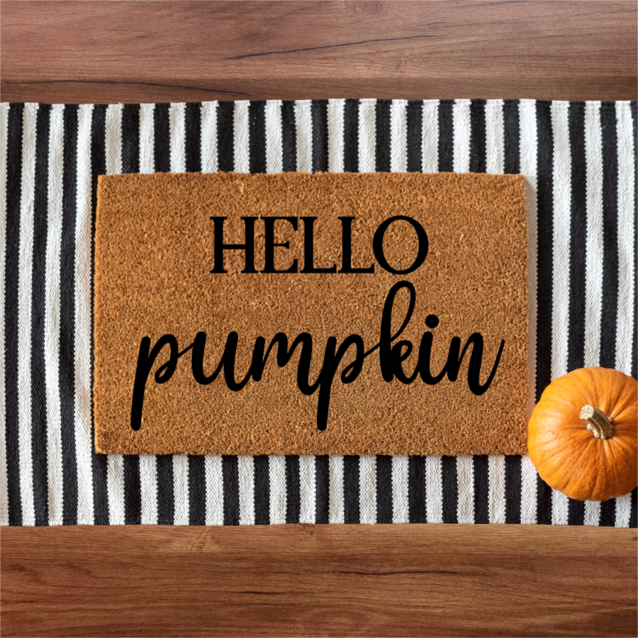 Doormat with 'HELLO pumpkin' text on a striped background with a small pumpkin.
