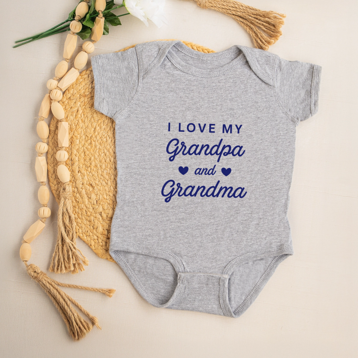 Gray baby onesie with 'I love my Grandpa and Grandma' text on a neutral background
