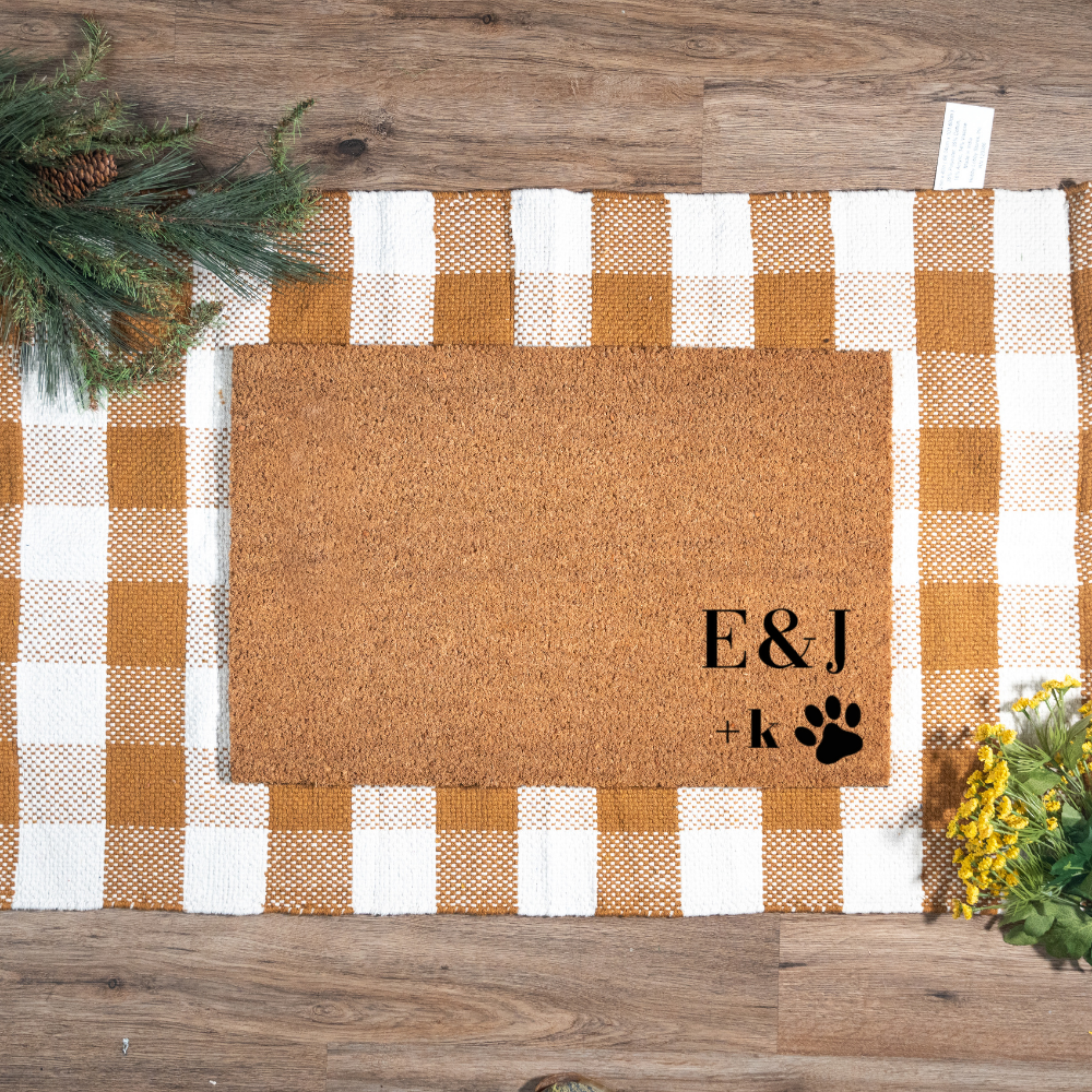 Doormat with 'E&J' and paw print design on a checkered mat