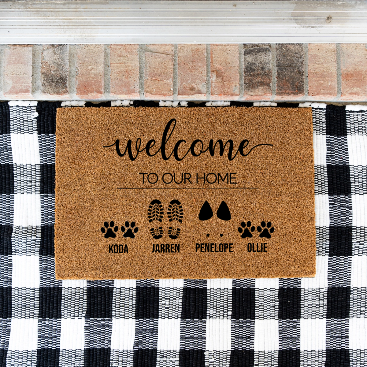 Doormat with 'welcome to our home' text and pet names on a checkered background