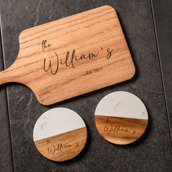 Wooden cutting board and coasters with 'the William's' engraving on a dark surface