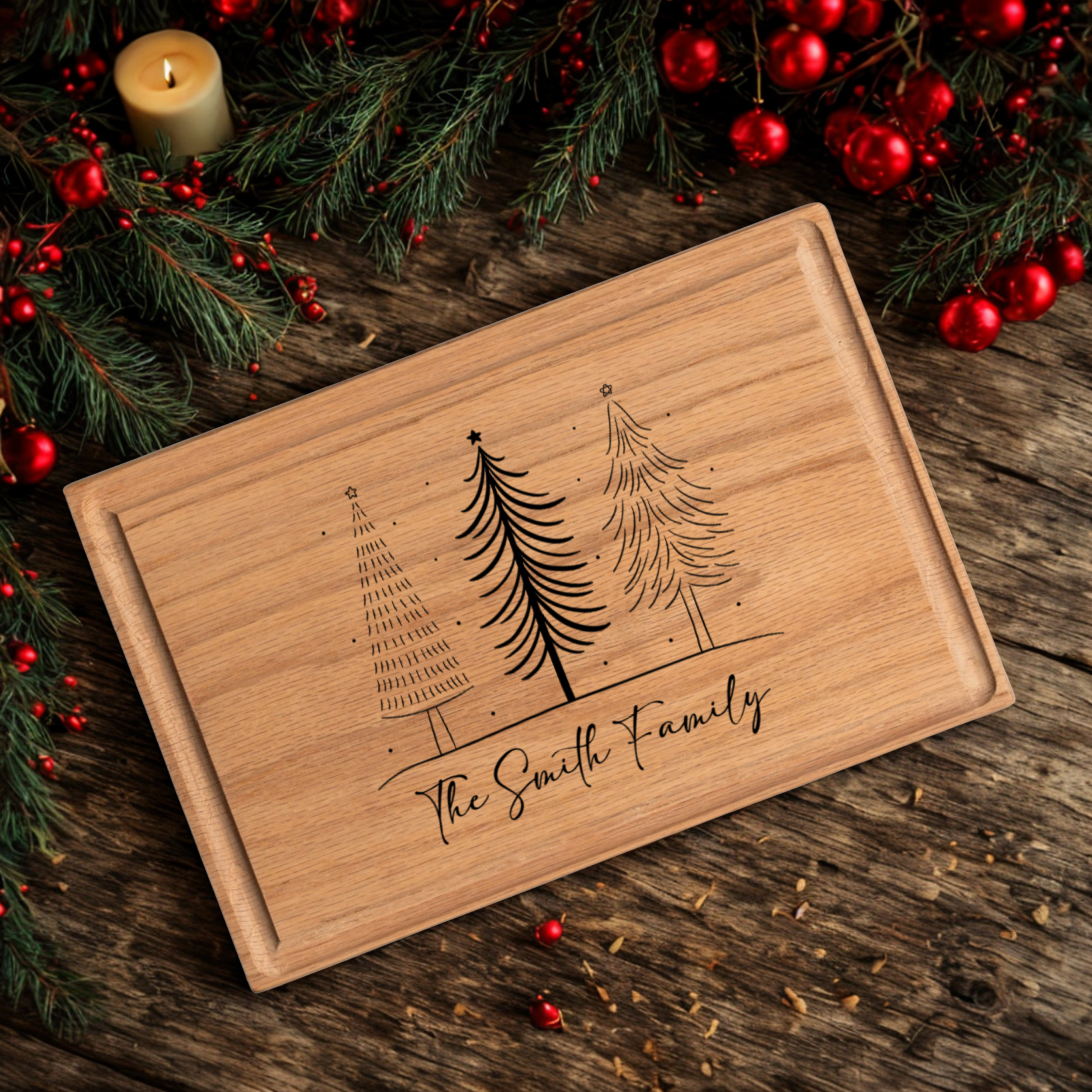 A custom cutting board engraved with three hand-drawn Christmas trees and “The Smith Family” in elegant script. The board rests on a dark wood table decorated with evergreen branches, red berries, ornaments, and a glowing candle. This festive design blends function and charm, making it an ideal personalized cutting board gift for Christmas gatherings and holiday kitchens.
